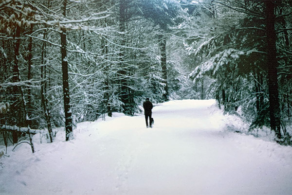 man walking on snowy road